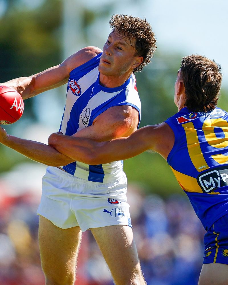 Nick Larkey fires off a handball as he's tackled by Brady Hough.