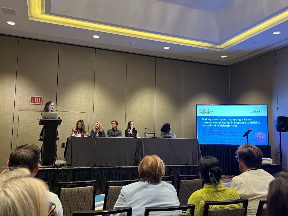 Panel sitting, slide says “making a swift pivot: adapting a 5-year stepped wedge design in response to emerging behavioral health priorities”