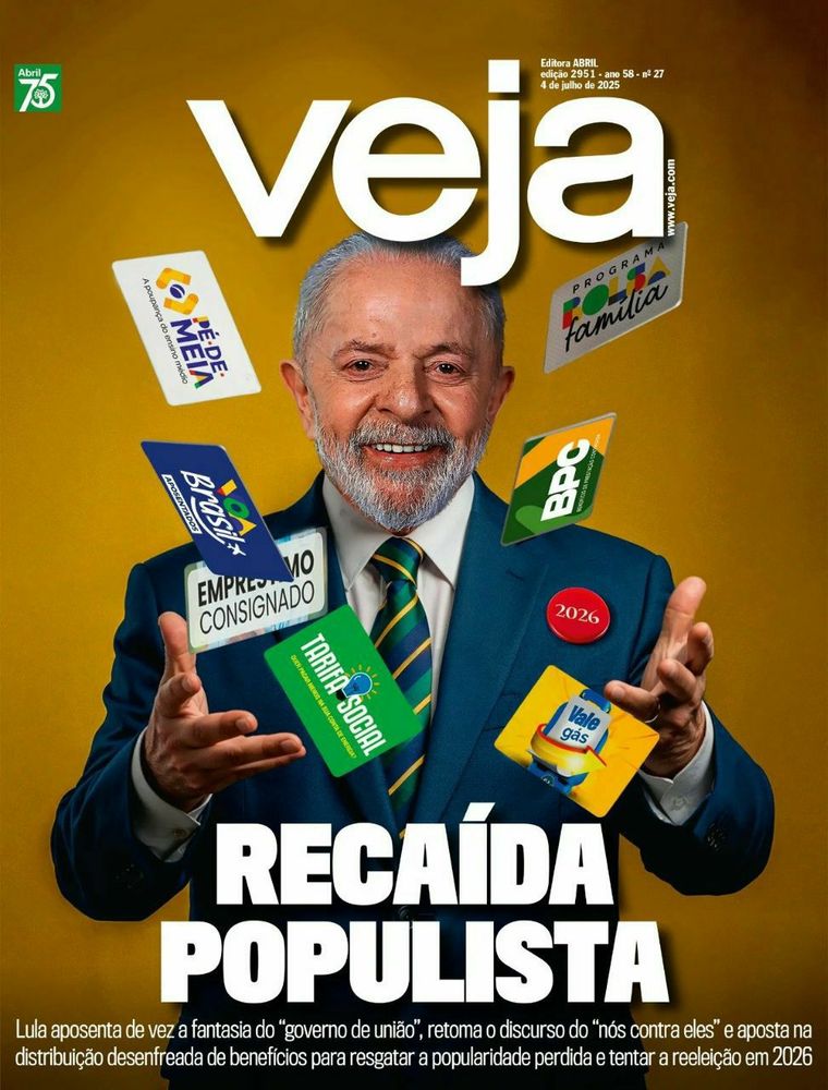 Lula aparece sorridente em traje formal, vestindo terno azul, camisa branca e gravata verde com listras amarelas. Ele está em posição frontal, com as duas mãos erguidas e abertas, como se estivesse distribuindo ou lançando ao ar diversos cartões de programas sociais. Entre eles, estão o cartão do Bolsa Família, Pé-de-Meia, Vale Gás, BPC, Tarifa Social, Empréstimo Consignado e Brasil Sorridente. Há também um botão vermelho com o número “2026” preso ao paletó, sugerindo candidatura à reeleição. O fundo é amarelo vibrante, e no topo da capa lê-se “Veja”. O título principal, em letras grandes brancas, diz “RECAÍDA POPULISTA”. A linha de apoio critica o que chama de abandono do “governo de união” e acusa Lula de apostar em uma “distribuição desenfreada de benefícios” para tentar recuperar popularidade e disputar novo mandato.