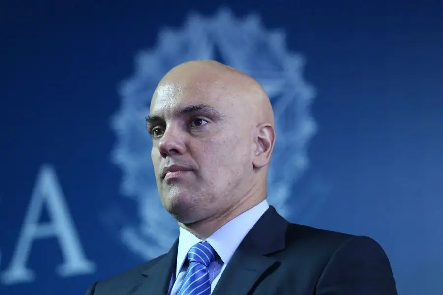 Alexandre de Moraes com o brasão da República ao fundo, formando um disco solar igual de santo.