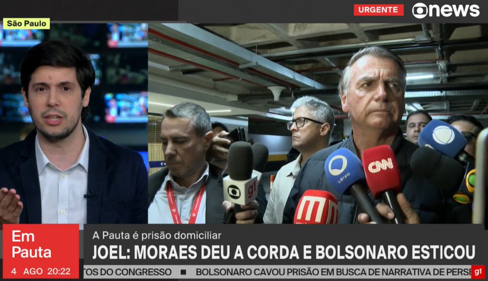 Imagem de uma transmissão ao vivo do canal GloboNews durante o programa "Em Pauta", exibido em 4 de agosto às 20h22. No canto esquerdo da tela aparece o comentarista Joel Pinheiro da Fonseca, em estúdio, falando diretamente para a câmera com expressão séria. No canto superior esquerdo há uma tarja amarela com o texto “São Paulo”, indicando a localização de Joel.

Do lado direito, aparece uma cena em um estacionamento fechado, com Jair Bolsonaro, ex-presidente da República, cercado por vários jornalistas e microfones de diferentes emissoras — entre elas Globo, CNN Brasil, SBT, BandNews, Record e Jovem Pan. Bolsonaro tem expressão fechada, tensa, e olha para frente enquanto escuta perguntas da imprensa. Ao redor dele, assessores e repórteres acompanham o momento.

No rodapé da tela, o destaque é a frase opinativa do comentarista, em letras grandes:
“JOEL: MORAES DEU A CORDA E BOLSONARO ESTICOU”, seguida do subtítulo:
“A Pauta é prisão domiciliar”.

Na faixa inferior, uma manchete contínua também em tom crítico diz:
“BOLSONARO CAVOU PRISÃO EM BUSCA DE NARRATIVA DE PERSEGUIÇÃO”.

No canto superior direito, aparecem as logos da GloboNews e a tarja vermelha com a palavra “URGENTE”, indicando a cobertura de um assunto quente.