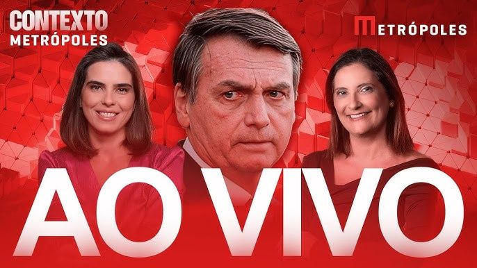 Card promocional do portal Metrópoles para o programa Contexto Metrópoles, com destaque para uma transmissão AO VIVO. No centro da imagem está o ex-presidente Jair Bolsonaro com expressão séria e o rosto em destaque, centralizado e em maior escala. À esquerda, aparece a jornalista Carla Araújo, sorrindo levemente e vestida de vermelho escuro. À direita, também sorridente, está a jornalista Denise Rothenburg, com blusa preta. O fundo é vermelho vibrante com formas geométricas abstratas, reforçando a estética de urgência e cobertura jornalística ao vivo. As palavras “AO VIVO” aparecem em letras garrafais brancas na base da imagem, indicando que o conteúdo está sendo transmitido em tempo real.