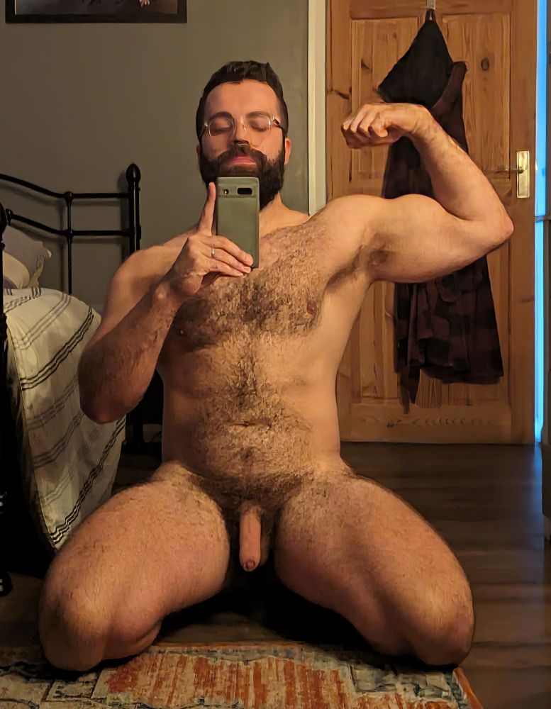 A selfie of me on my knees, naked and flexing my bicep. 