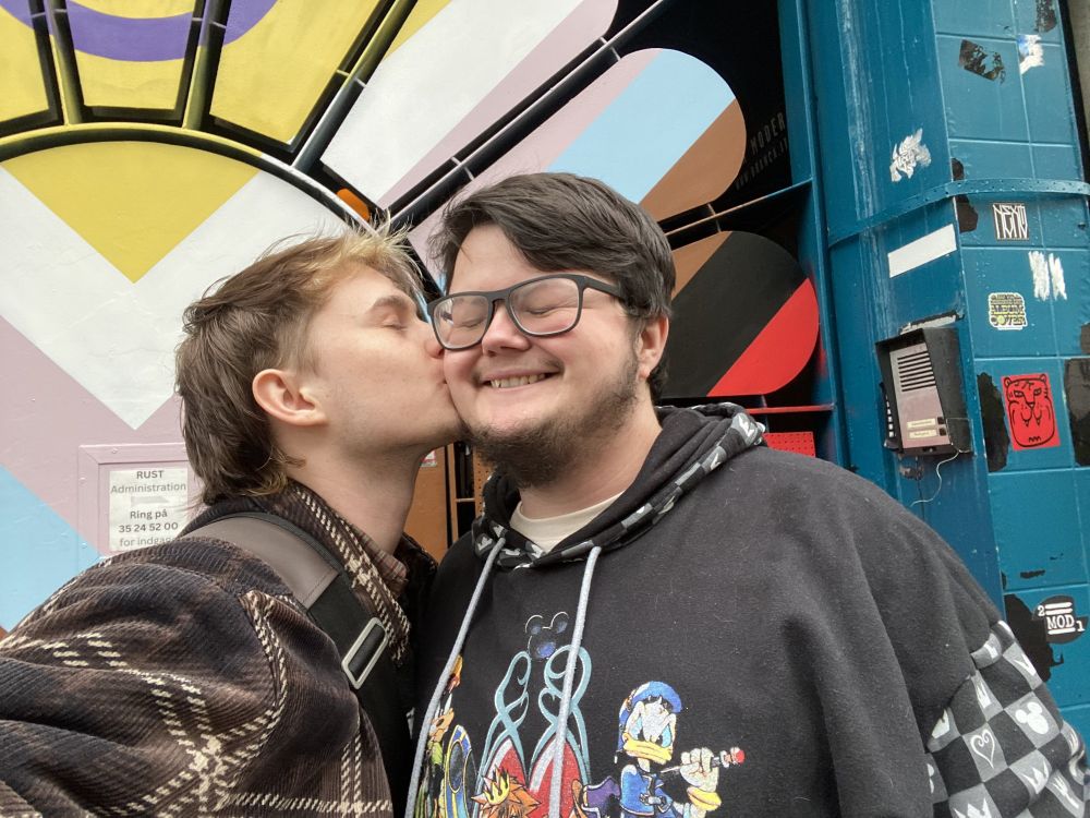 irl photo of raxyn and cosmic. cosmic is kissing raxyns cheek