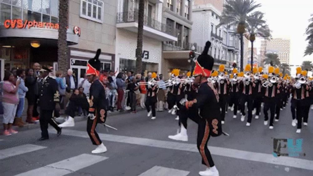 a marching band is marching down a street in front of a cvs pharmacy