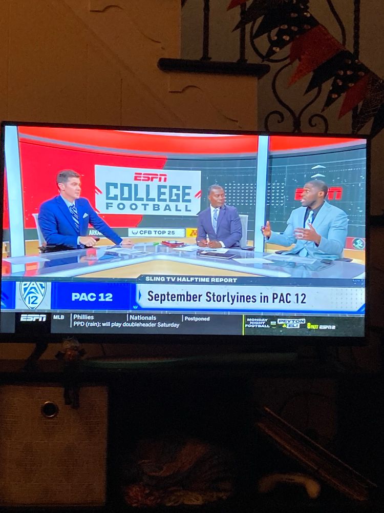 ESPN College Football broadcast desk conversation with “September Storlyines in PAC 12” as the bottom label during the “Sling TV halftime report” (“storlyines” should presumably say “storylines”; this was a typo on the national broadcast of a multibillion dollar company)