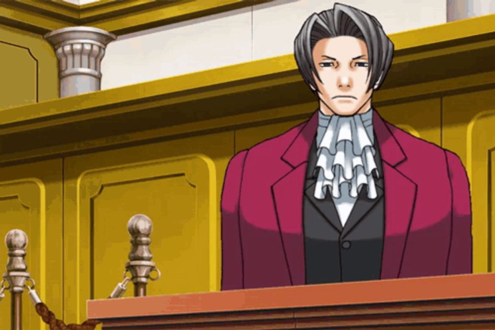 a man in a red suit and tie stands in a courtroom