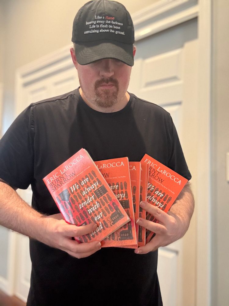 Eric holding a bunch of ARCs of Burnt Sparrow Book 1