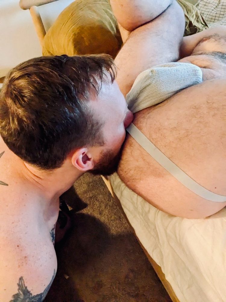 Bobby eating my ass. I’m on a bed with my legs up, wearing a white jock strap.