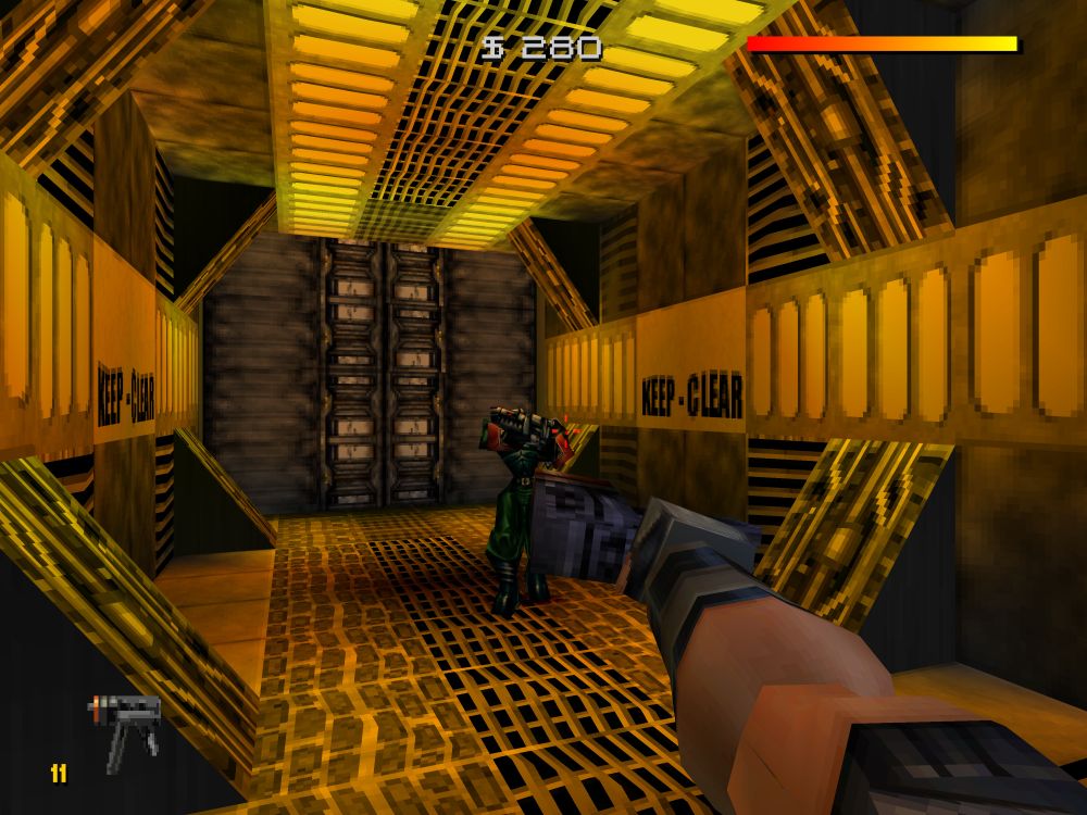 An octagonal hallway with a large bulk head at the end with very warm golden yellow/orange lighting, seen from the first person.

Hawk is extending his arm and doing the gangsta sideways gun thing, aiming it at a poor scared enemy that's literally holding his gun in over his face in fear, pooping his pants.

The words KEEP - CLEAR are display on both side walls of the hallway. The thug obviously didn't follow that advice.