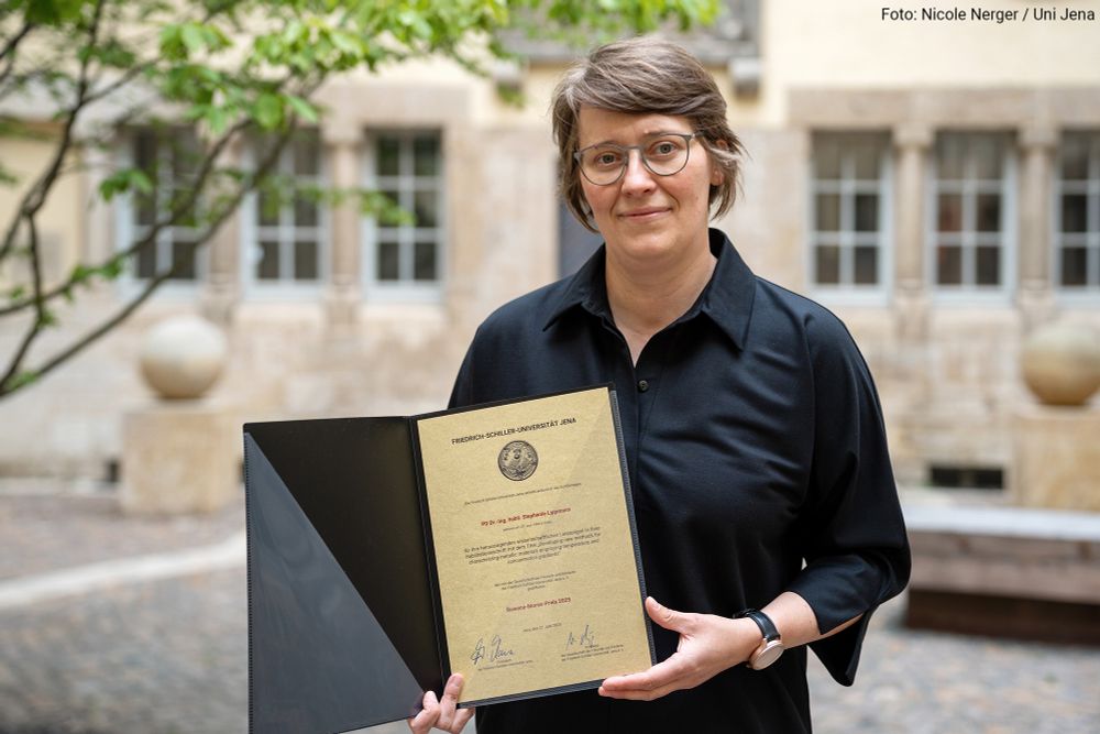 PD Dr habil. Stephanie Lippmann with the Rowena Morse Prize certificate during Schiller Day 2025 in the small courtyard of the University of Jena.