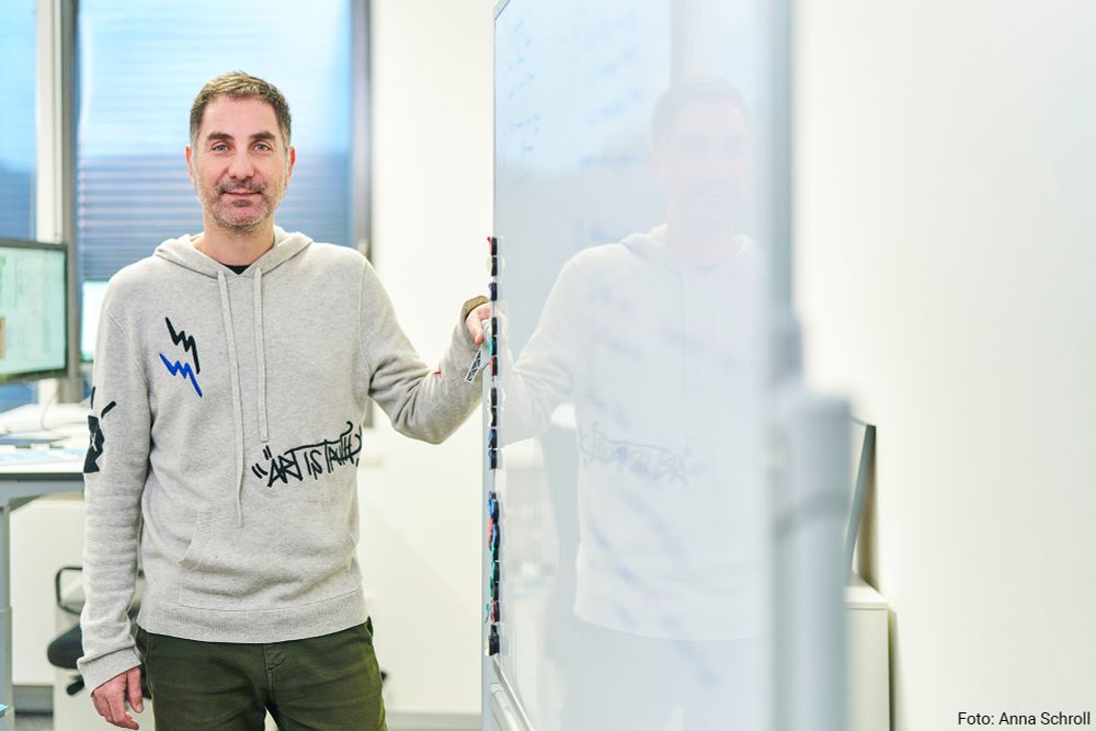 Gianni Panagiotou, Professor of Microbiome Dynamics, standing next to a whiteboard.