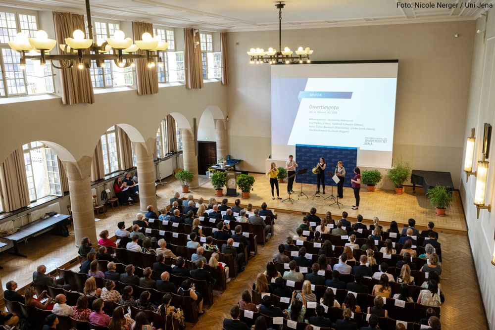 View into the auditorium of the University of Jena during the festive event for Schiller Day 2025, with the wind quintet Quintetto Abbraccio on stage.