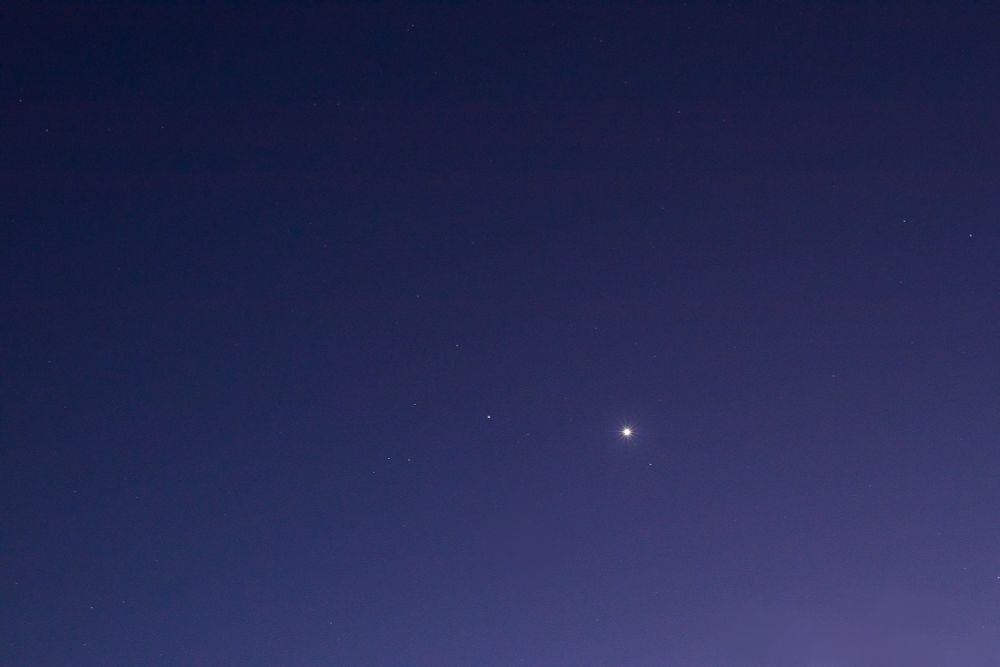 the same area of sky but it's darker - more stars are visible and saturn and venus appear brighter. the sky is more purple and deep