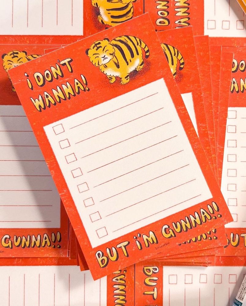 my best selling notepad of a cute grumpy tiger with my store name centrally displayed