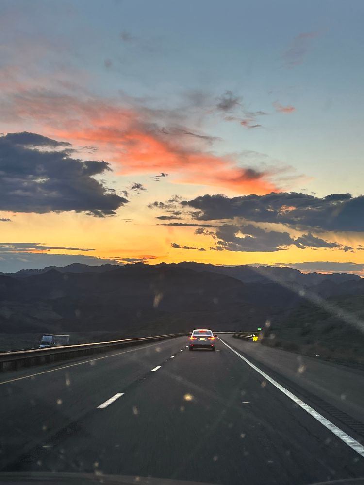 Sunset over mountains driving down a highway in Nevada 