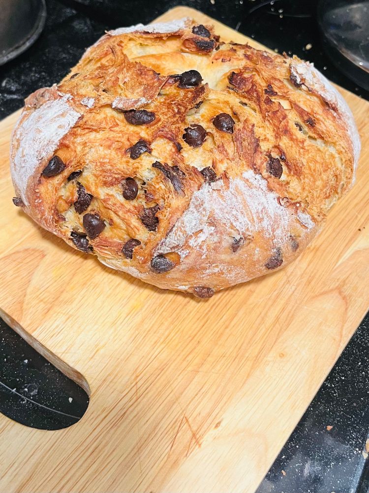 Loaf of homemade chocolate chip bread On a cutting board in a kitchen 