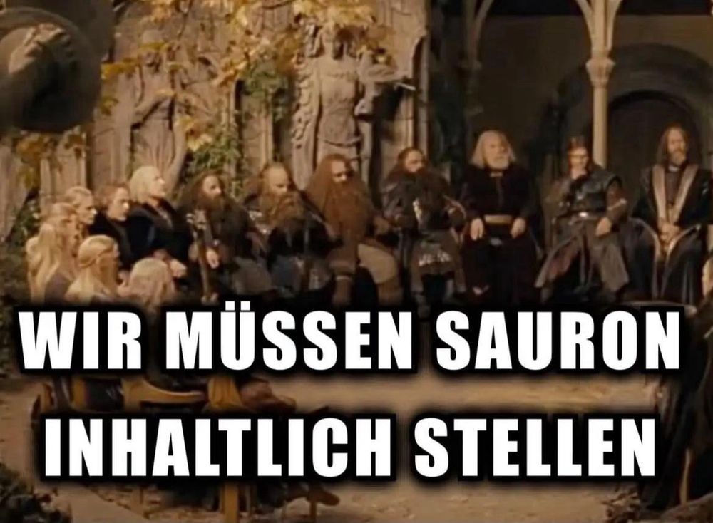 Szene aus „Der Herr der Ringe“: Der Rat von Elrond sitzt in Bruchtal im Halbkreis beisammen. Über das Bild ist in großen weißen Buchstaben mit schwarzer Umrandung geschrieben: „WIR MÜSSEN SAURON INHALTLICH STELLEN“.