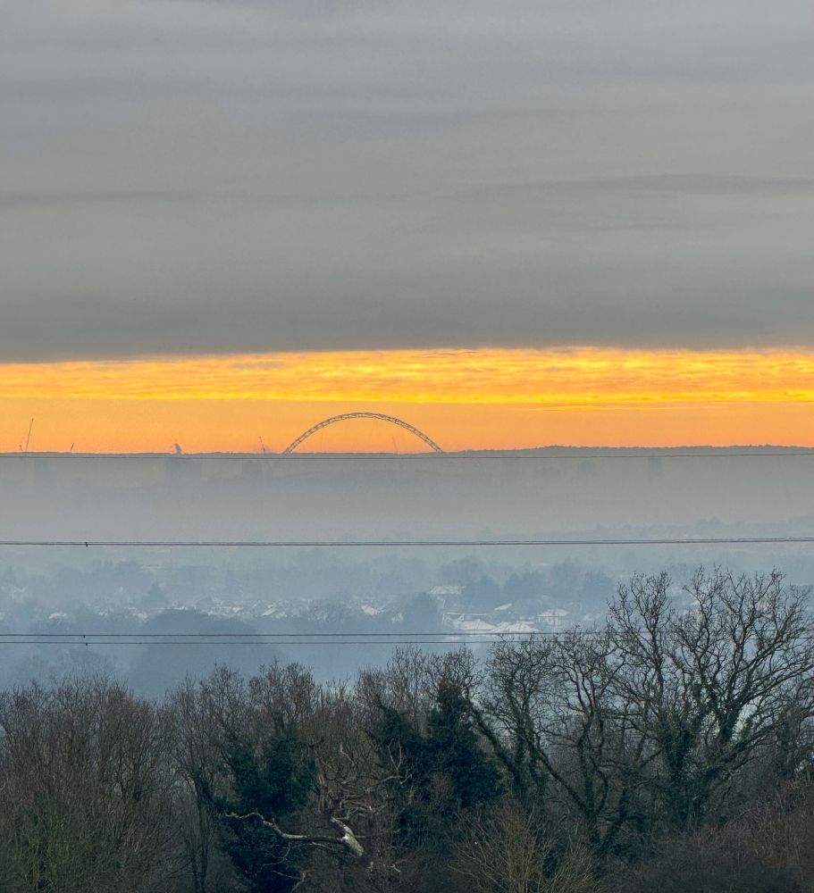 Golden and blue sky at midday in London with Wembley arch. 