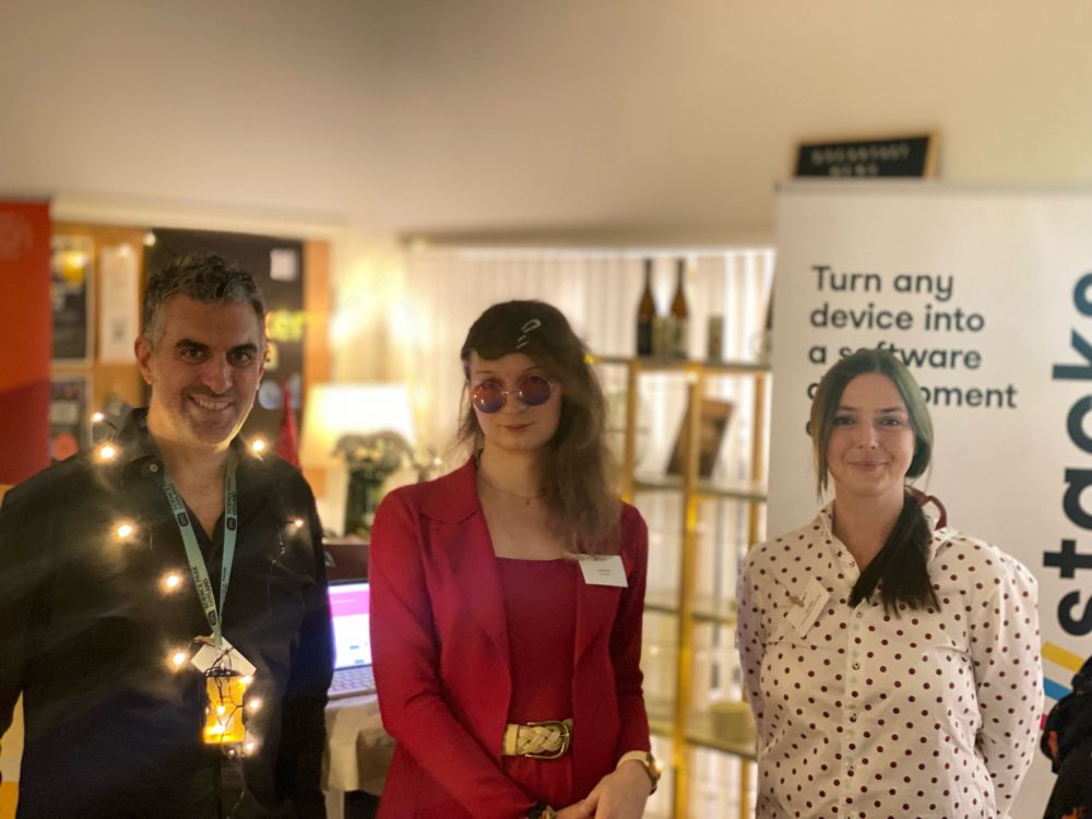Group picture of Daniel Freeman, Jamie Kerber and Liliia Chorna standing in front of a DevStacks standing poster at Science Park Gotland