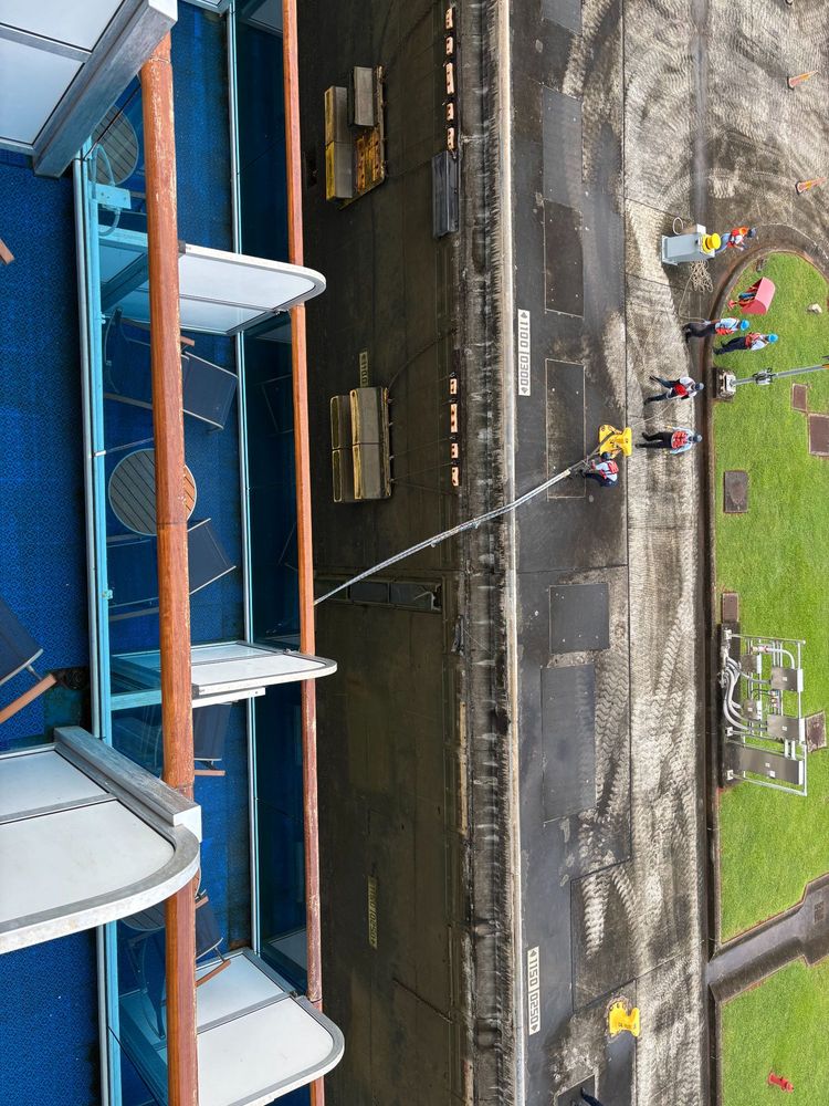 Looking down into the Panama Canal from the 11th floor of a cruise ship, showing a small gap between the ship and the lock wall.