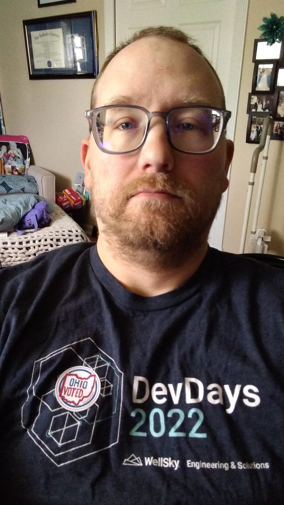 Selfie of me in a dark blue t-shirt with an "I voted" sticker on it.