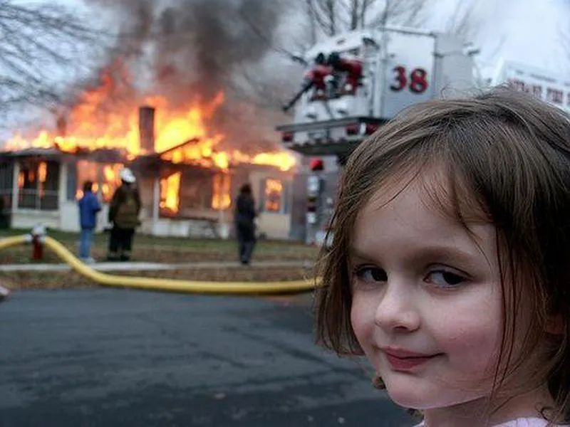 little girl looking evil next to a house fire meme. 