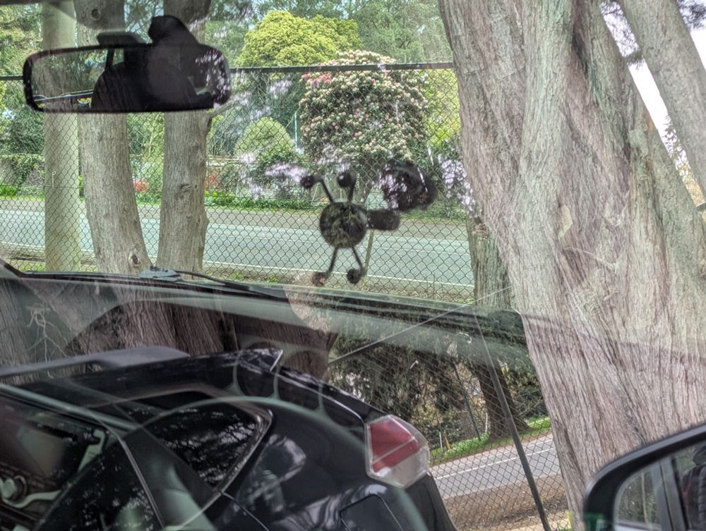Photo showing a car with a phone mounted in almost the middle of the windscreen.