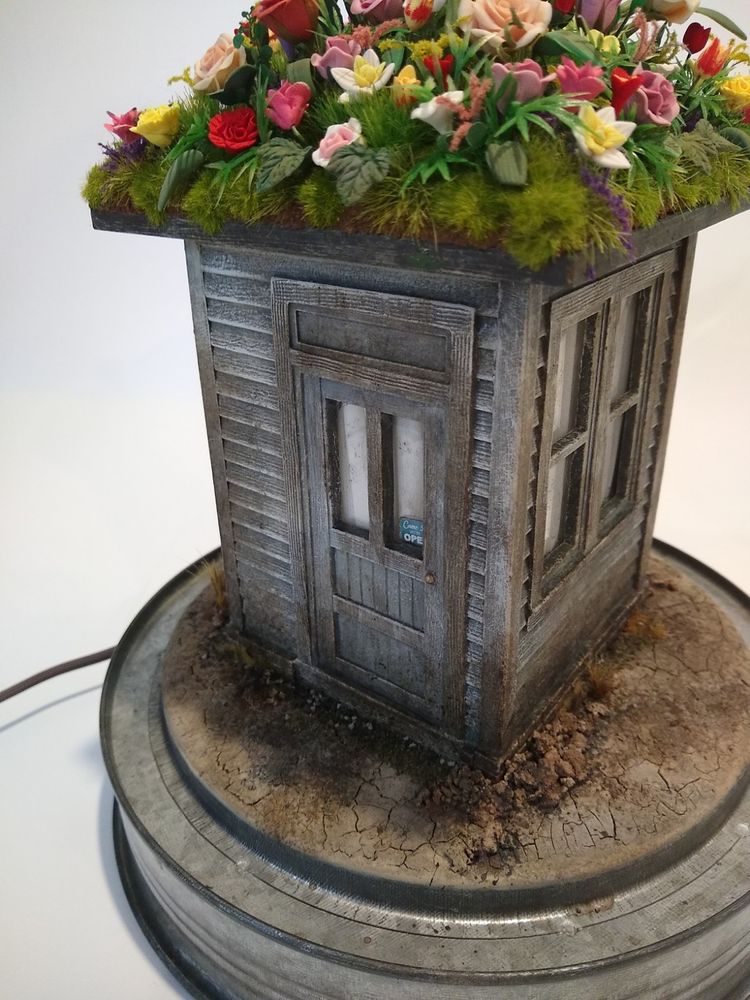 Flowers done, house affixed to base and painted with additional details, aging, and dirt near the base.
