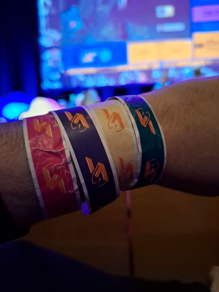 4 bracelets en papier de Speedons pour les 4 jours de l'évènement avec la scène visible en fond.