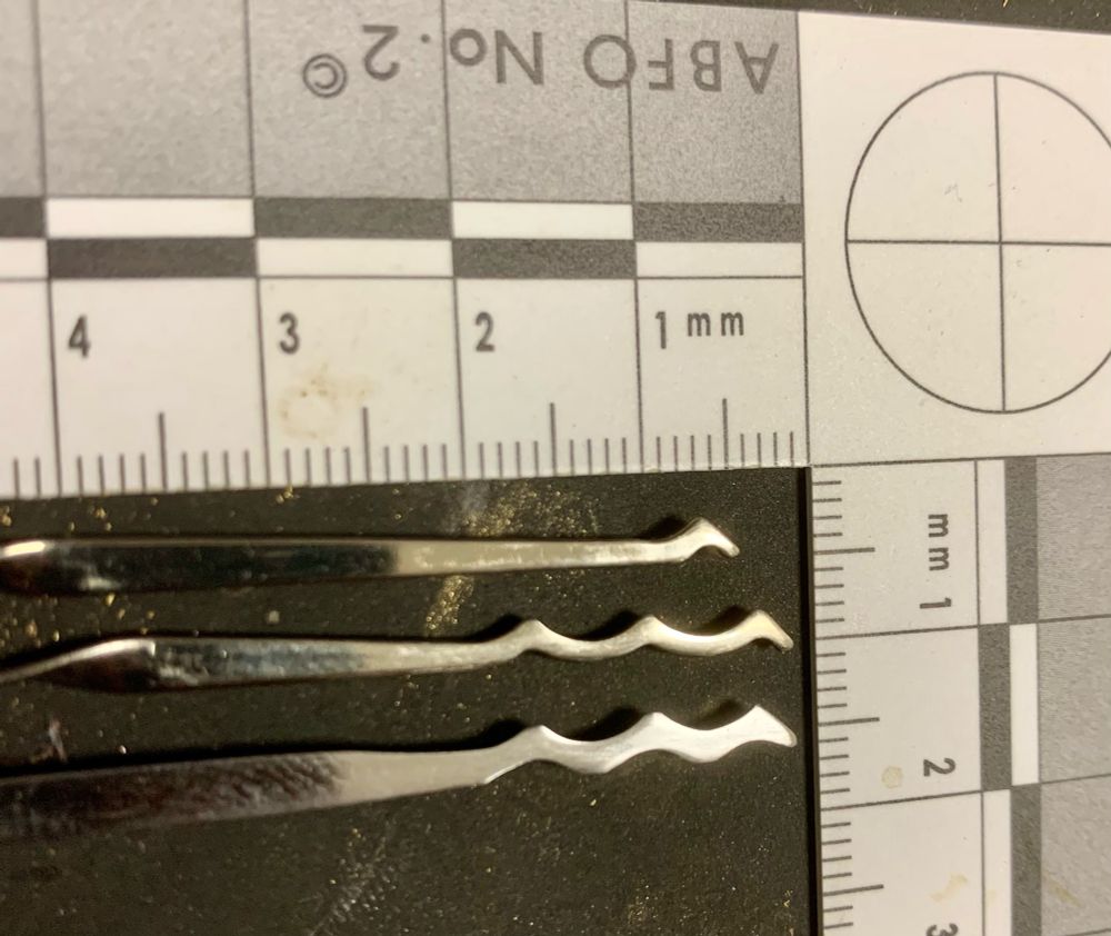 My first attempt at making a Bogotá style triple peak pick from a recycled street sweeper blade (bottom), with two commercial picks (either from Storm, or Mad Bob, I forget which) above it. Mine is not quite as refined, but not bad for a first attempt with only a small file and some sandpaper. 