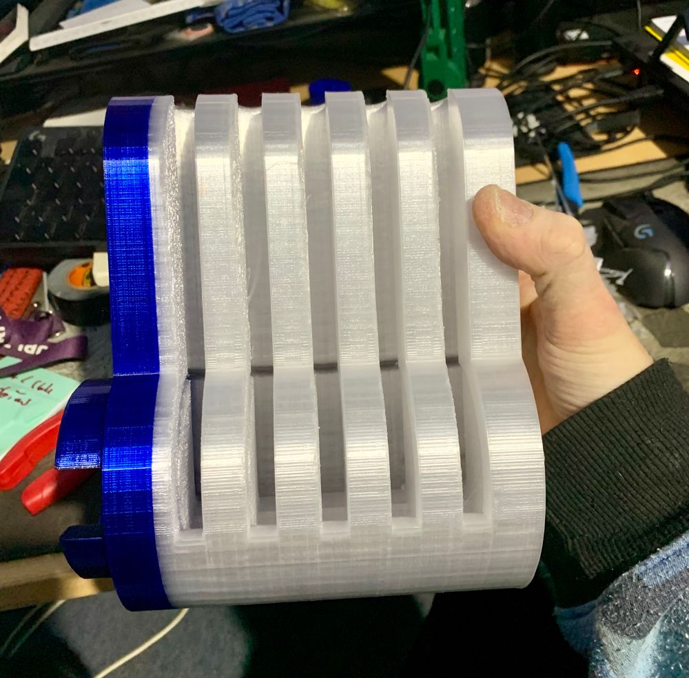 An oversized 3D printed cutaway lock body and plug, after removing bridging material, assembled to see if they fit together (side view). I ran out of clear filament, so the back part is in a local shade of blue. 🤣