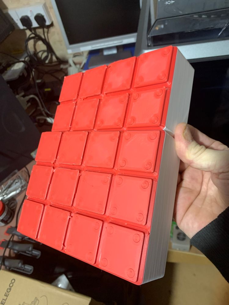 The bottom view of some 3D printed gridfinity storage bins (one 2x4x6, one 3x4x6). I started printing them in red, but ran out of filament just after the base was done and had to swap to white - so have ended up with two tone bins with red bases and white walls. It looks quite good, considering it was an accident. lol. 