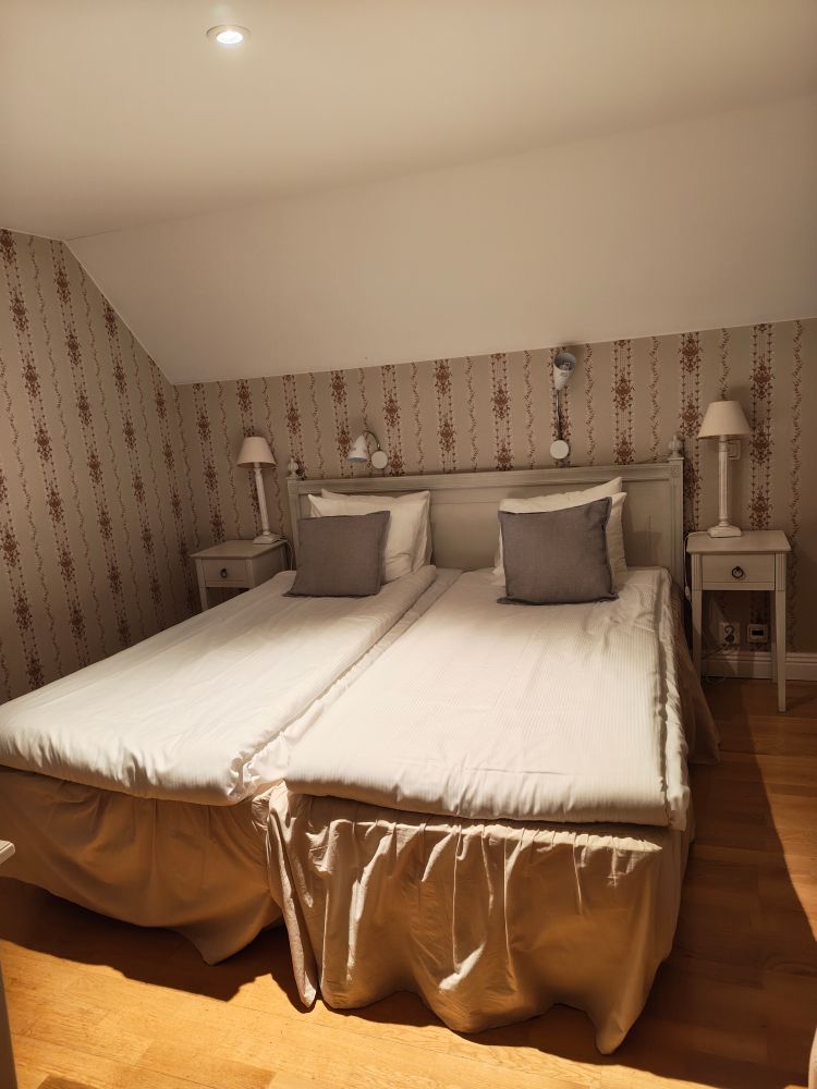 Photo of the hotel room. It's very cozy and feel a bit old school/rustic. The interiors go in beige and brown colours.