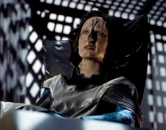 Makbar, an archon or judge of the Cardassian court, with the blue makeup on the spoon of her forehead and the elaborate hairdo.
