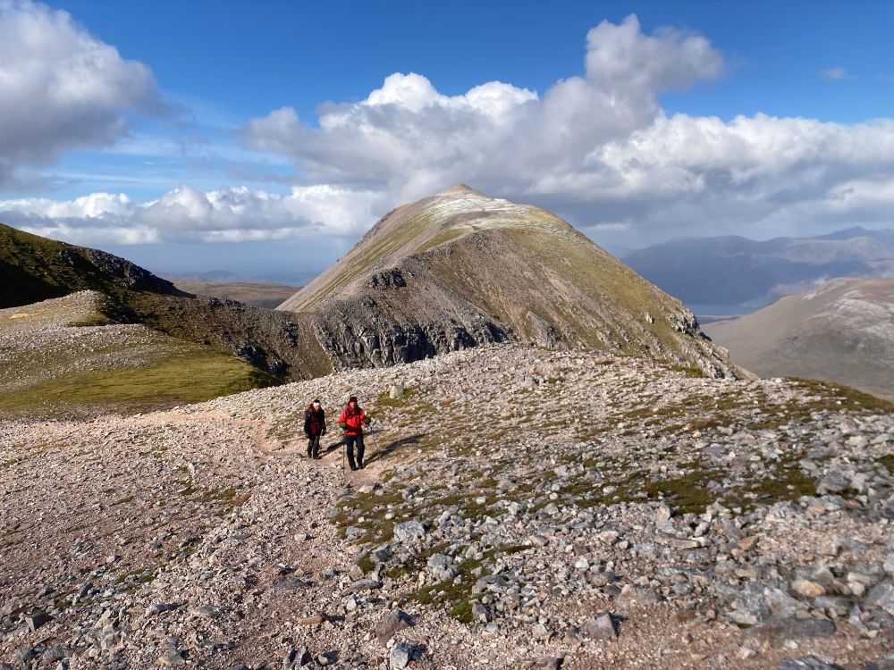 Two people on a rocky mountain, Beinn Eighe in Torridon. Sunny skies. 
