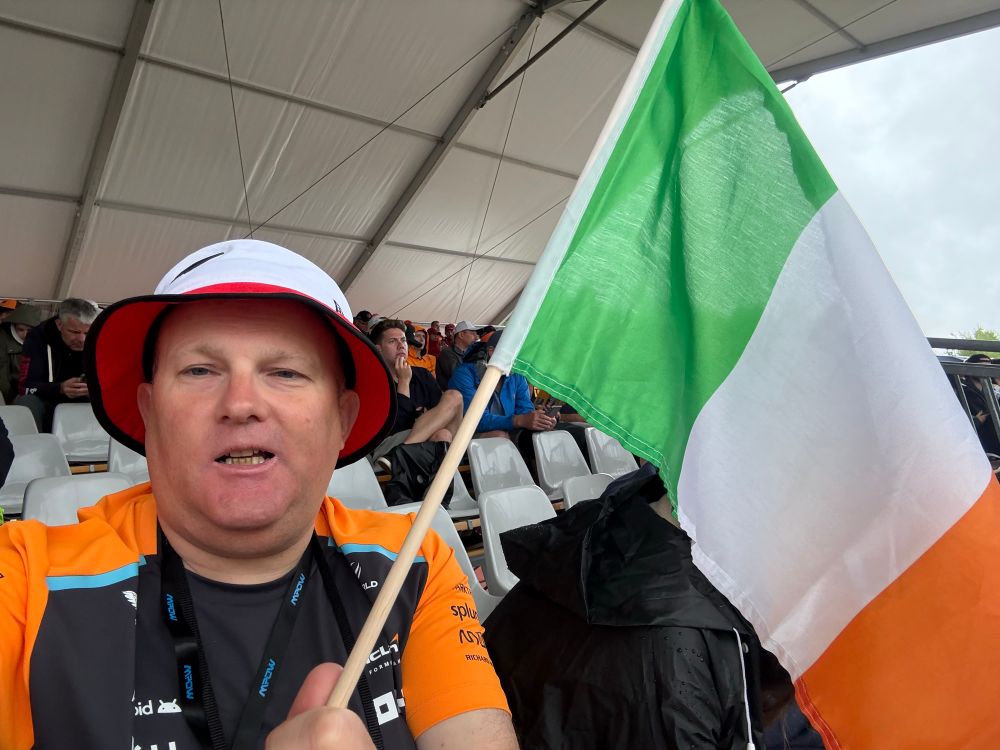 Paul in the stand at Spa Francorchamps,wearing a McLaren top and bucket hat and holding up a Tricolour🇮🇪 on a stick