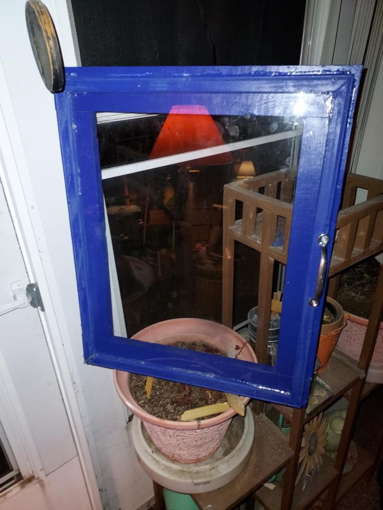 A new door using planks of wood for strength, with a picture frame screwed to the front for the window. I screwed a doorhandle in.
