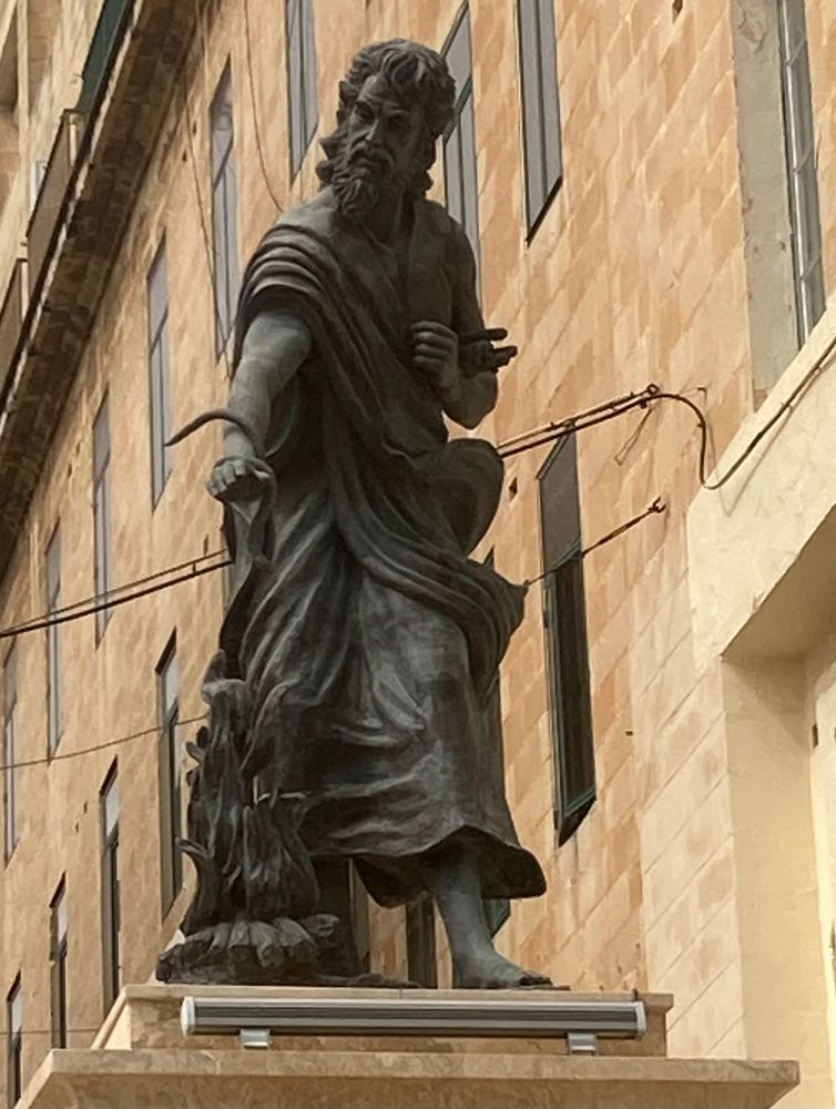 A statue of St Paul holding a snake.