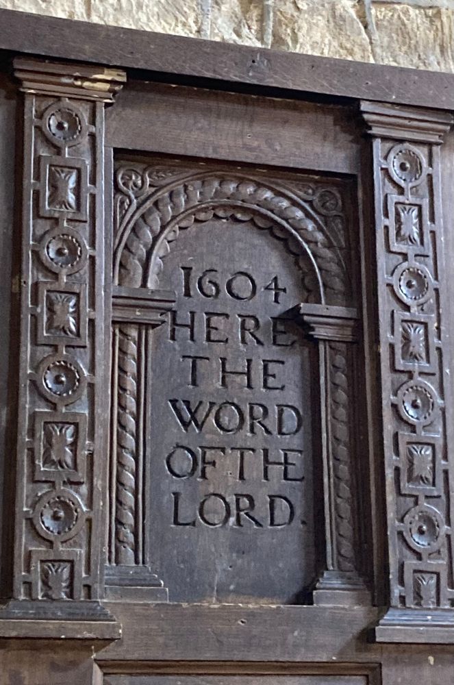 A wooden panelling section engraved with 1604 Here the word of the Lord.