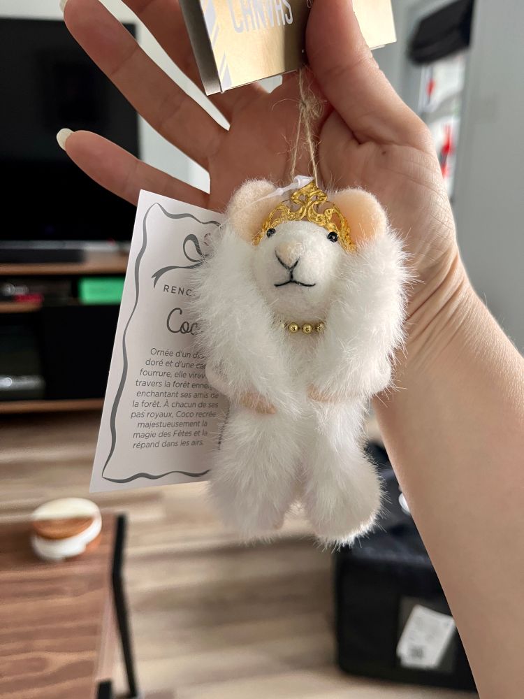 Une décoration dd Noël de souris full diva avec son manteau de fourrure blanc, son collier de perles et son diadème.