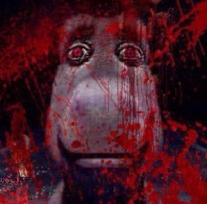 Visage de l'âne de Shrek vu de face avec des yeux rouges. Sur la photo on été rajouté des éclaboussures rouges qui ressemblent à du sang, donnant une tonalité lugubre à l'image et à l'âne 