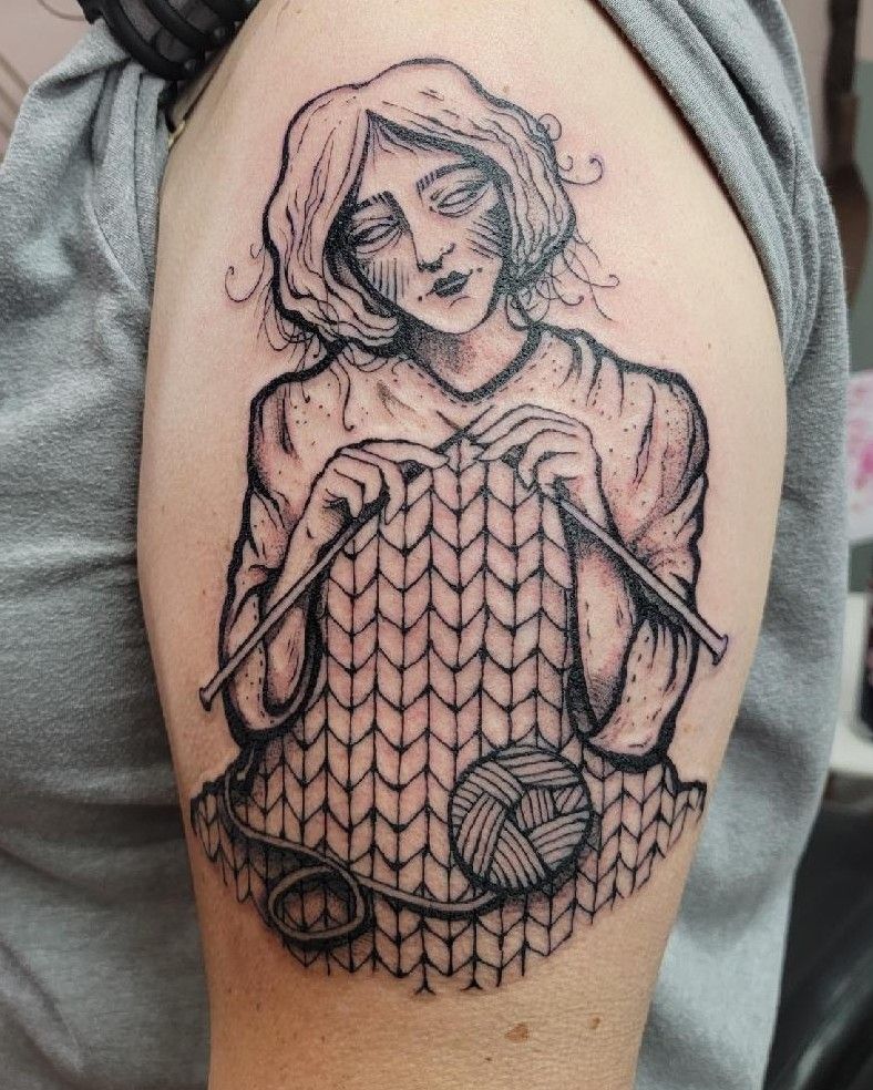Tattoo: A woman knits or crochets (I get confused) a large patterned piece. Her hands hold knitting needles, and a ball of sound yarn is on her lap. Her hair has rather lovely loose hairs drifting about.