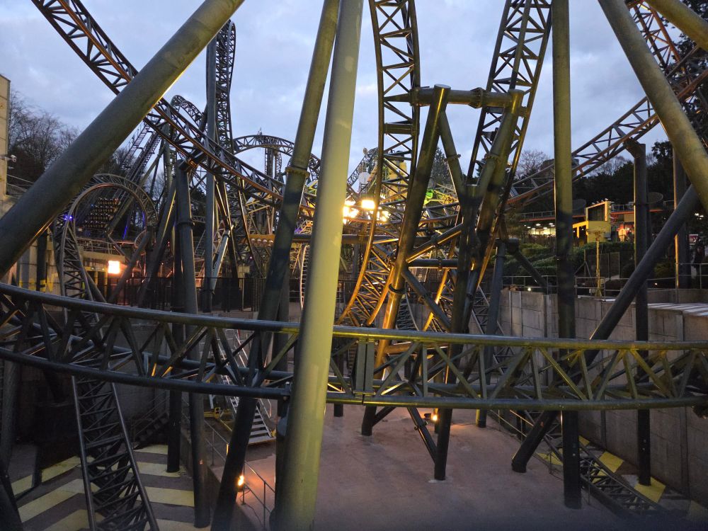 A photo of The Smiler at sunset, lit up with yellow lights.