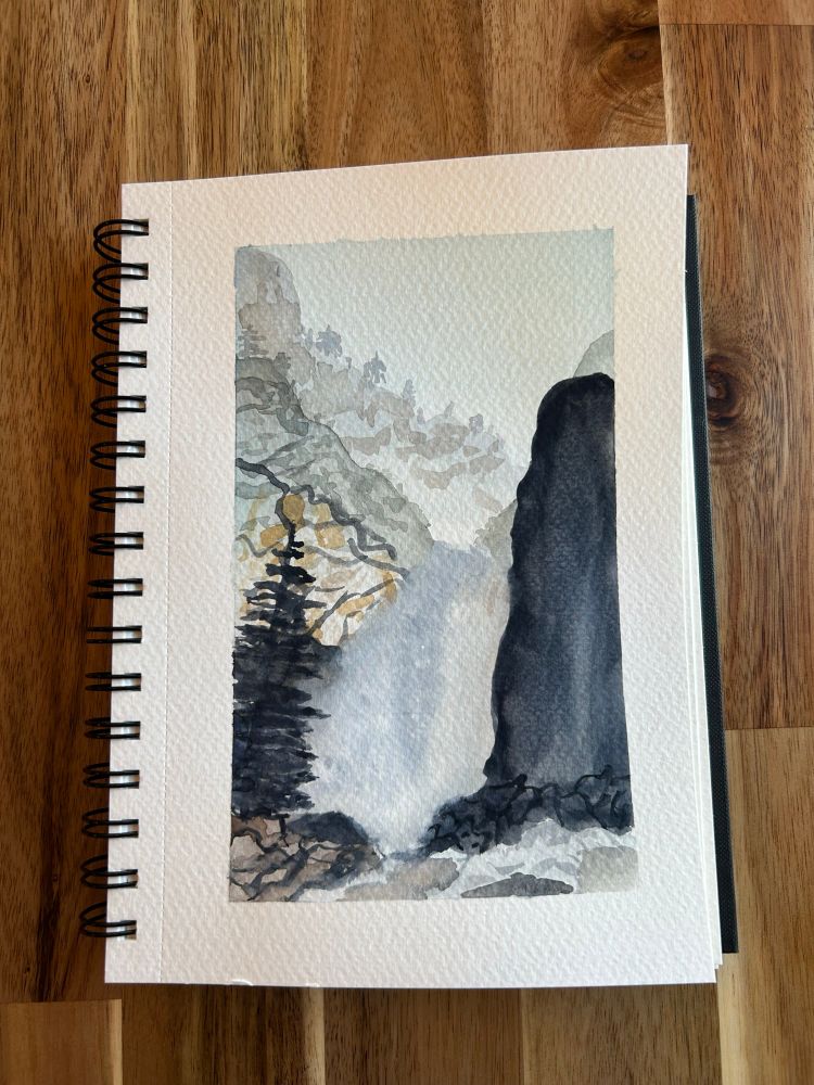 Watercolor painting of a misty waterfall going between a craggily mountainside and a black rock with water rapids and an evergreen tree in the foreground 