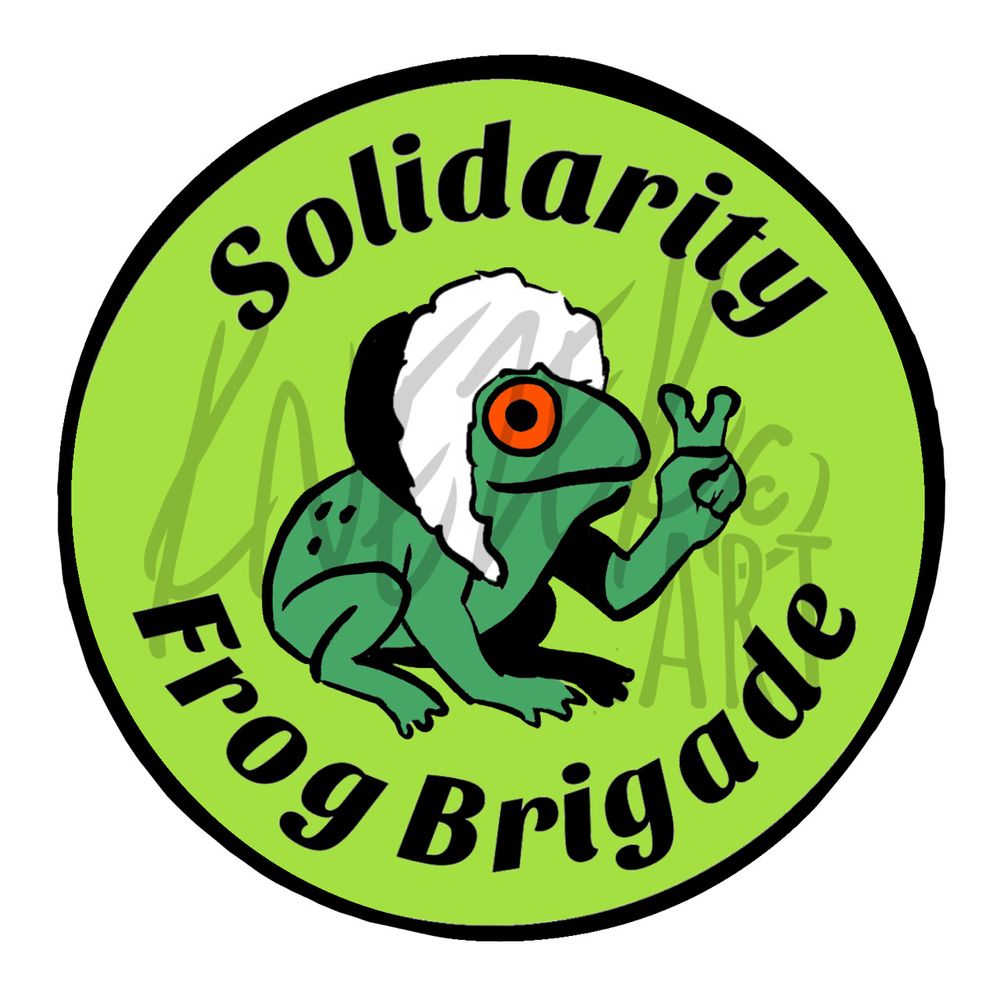 A round green sticker design, with bold black text around the outside reading “Solidarity Frog Brigade” and a little red-eyed frog, wearing a furry hat & making a peace sign with one hand, sitting in the center.
