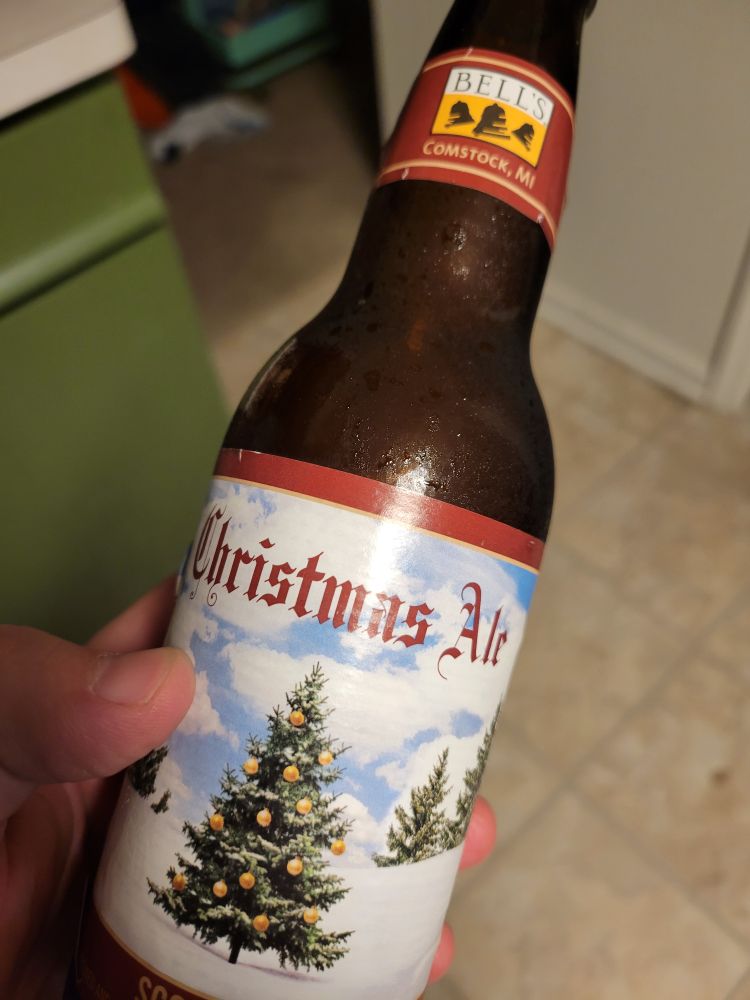 Photo of my left hand holding a bottle of the "Christmas Ale" by Bell's brewing