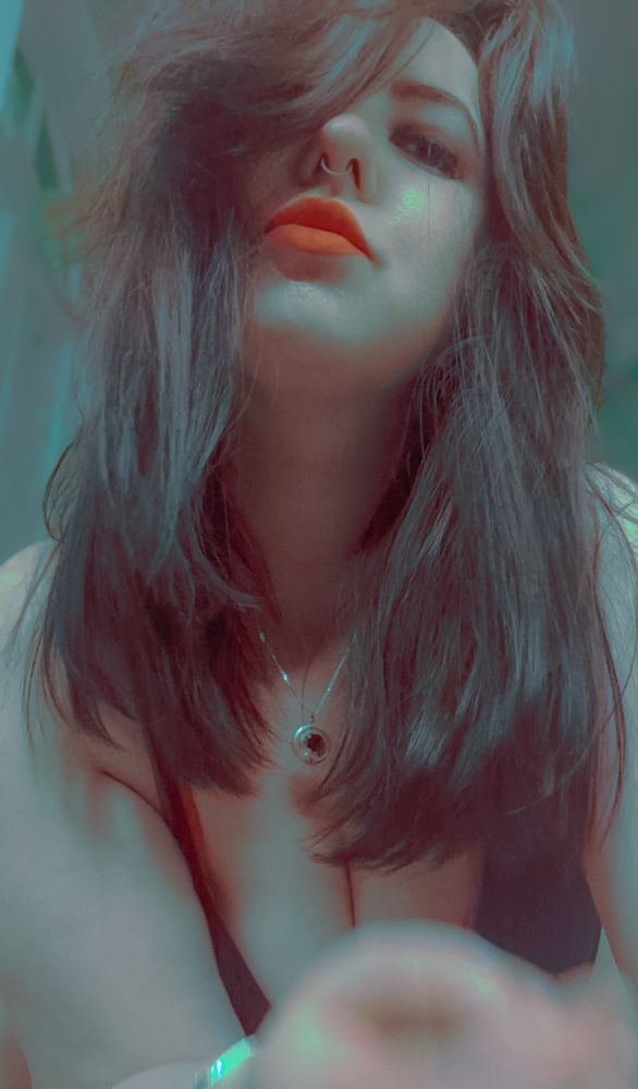 Woman looking down at a camera as if pinching your collar