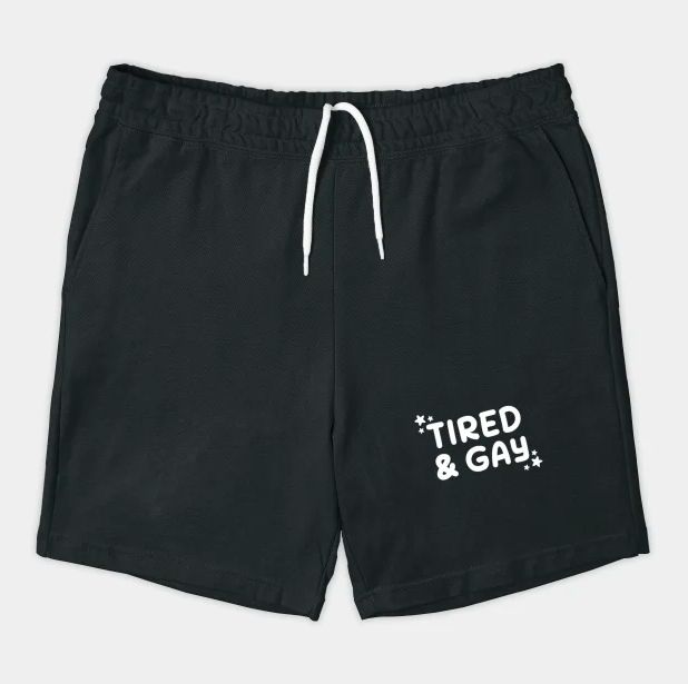 Image of a pair of cotton shorts: "tired and gay" is written at the bottom of the left leg