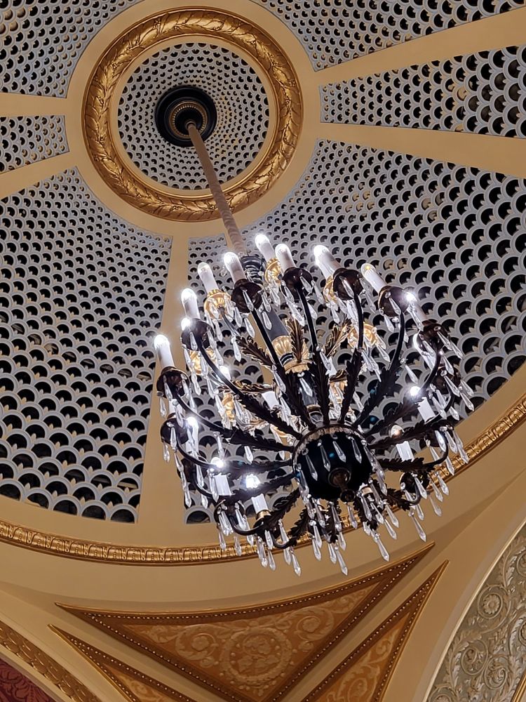 Central chandelier in the middle of the theater proper.  It looks made of wrought iron and crystal.  It has been upgraded to electric.  